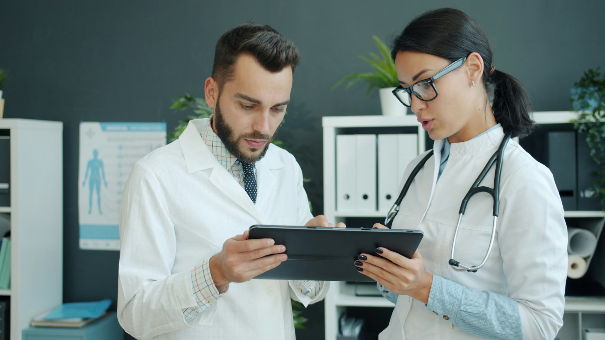 Two physicians reviewing clinical information on a tablet together